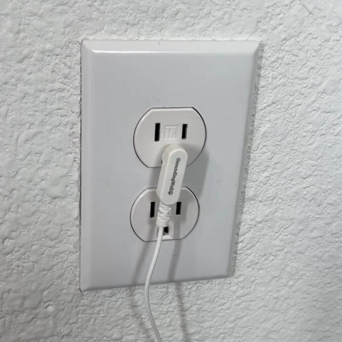 Grounding cord plugged into wall outlet